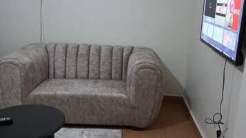 Departamento Deluxe | Área de sala de estar | Smart TV de 24 pulgadas con canales digitales