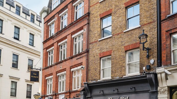 A row of multi-story buildings with a mix of architectural styles, including brick and cream-colored facades. - Charming Flat in Covent Garden (Greater London)