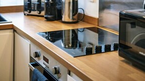 A modern kitchen with a built-in stove, a toaster, and a kettle on the countertop. - Charming Flat in Covent Garden (Greater London)