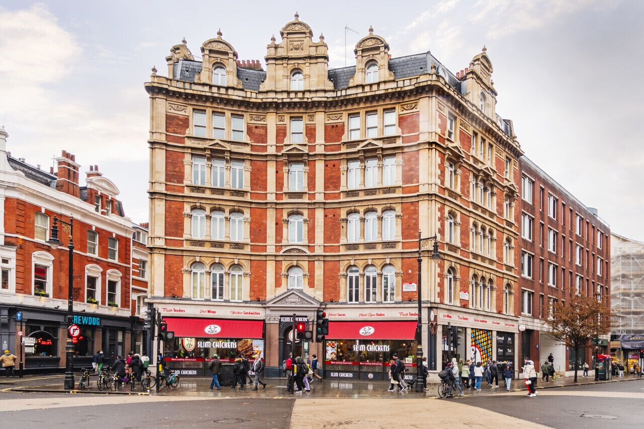 A historic building with a corner entrance, multiple stories, and a mix of brick and stone facades.