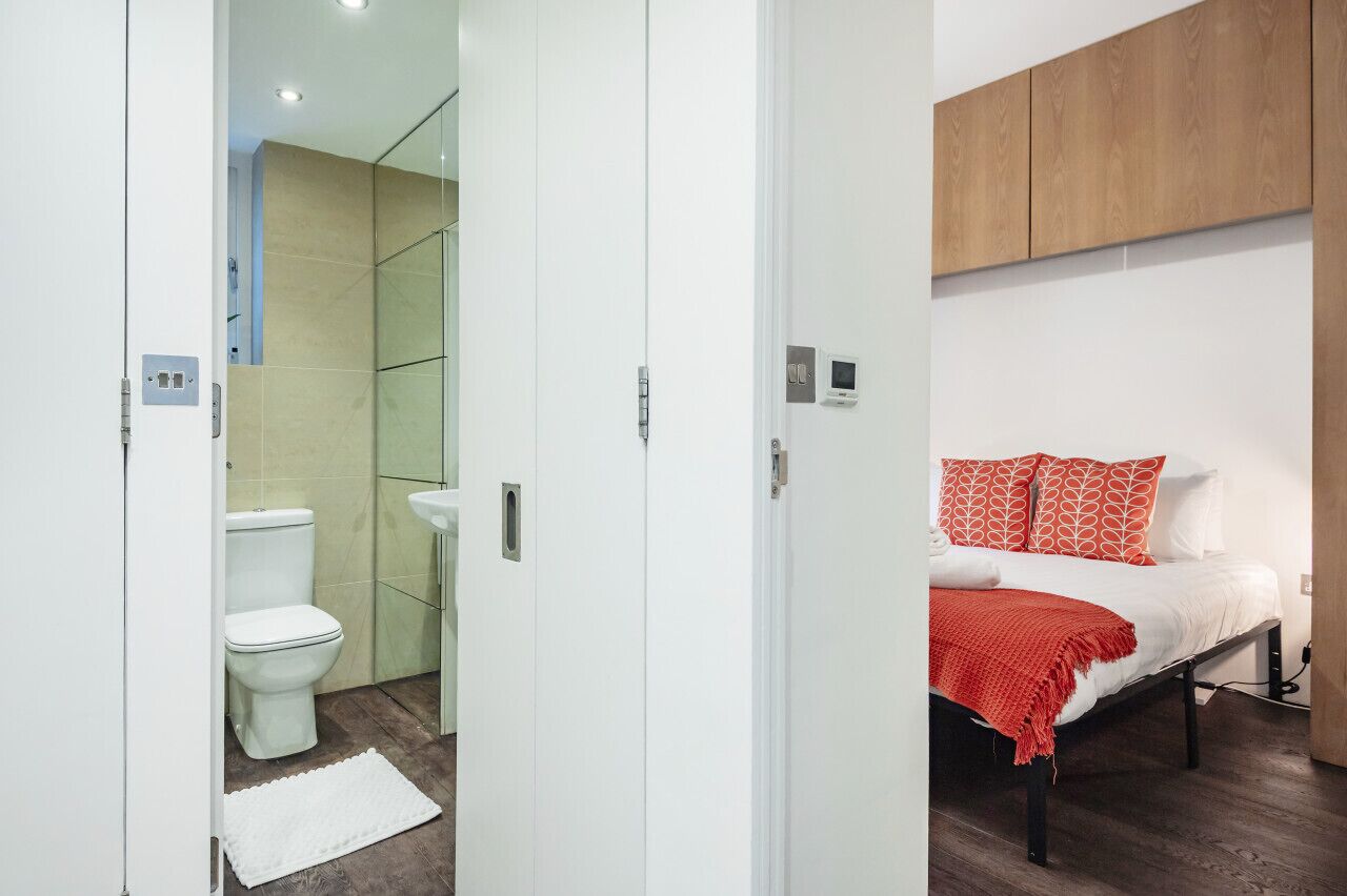 Een moderne slaapkamer met een bed, een nachtkastje en een bijzettafeltje.