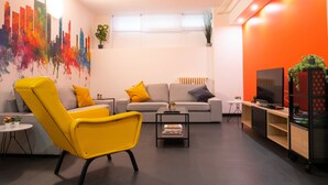 Een moderne woonkamer met een bank, fauteuil, salontafel en tv-meubel.