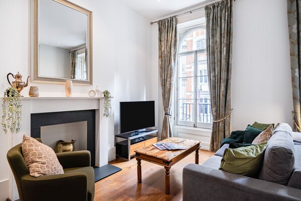 A living room with a fireplace, a television, and a sofa.