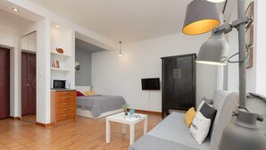 A modern living room with a sofa, a coffee table, a lamp, a TV, and a wardrobe.