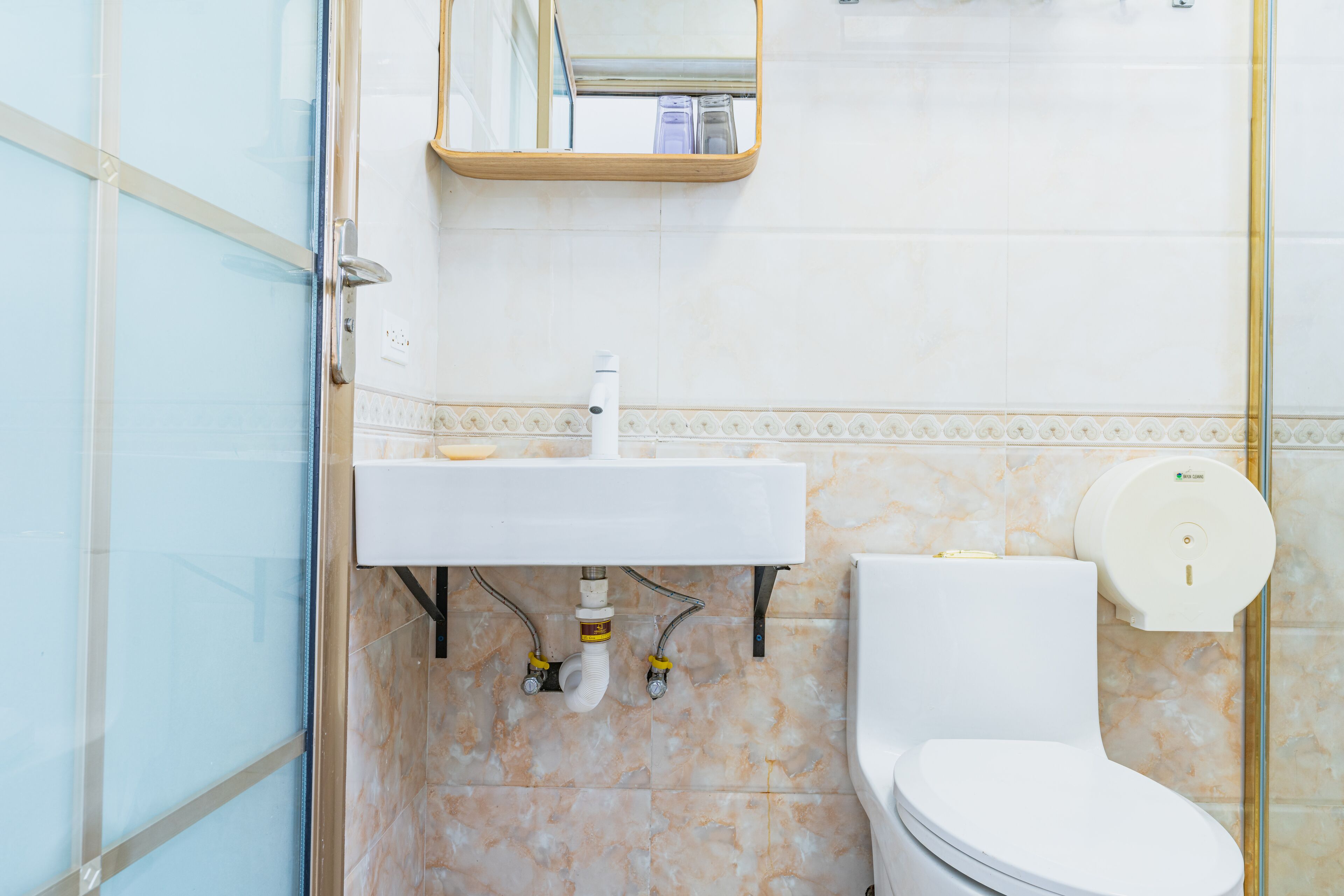 A bathroom with a white sink, a toilet, and a glass shower enclosure.