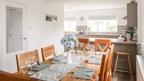 A modern kitchen with a dining area. - Llwyn Eithin (Holyhead)