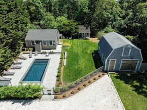 A residential property with a swimming pool, two houses, and a fenced yard. - Heated Plunge Pool, Game Barn, AC, 5 Min to Beach! (Chatham)