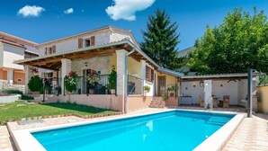 A two-story house with a swimming pool, a covered patio, and a stone wall. - Amazing home in Vrsar (Vrsar)