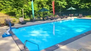 A swimming pool with lounge chairs and umbrellas. - Abundant Views- Ultra-private and spacious cabin with abundant mountain views! (Sevierville)