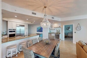 A spacious kitchen with a central island, modern appliances, and a chandelier.