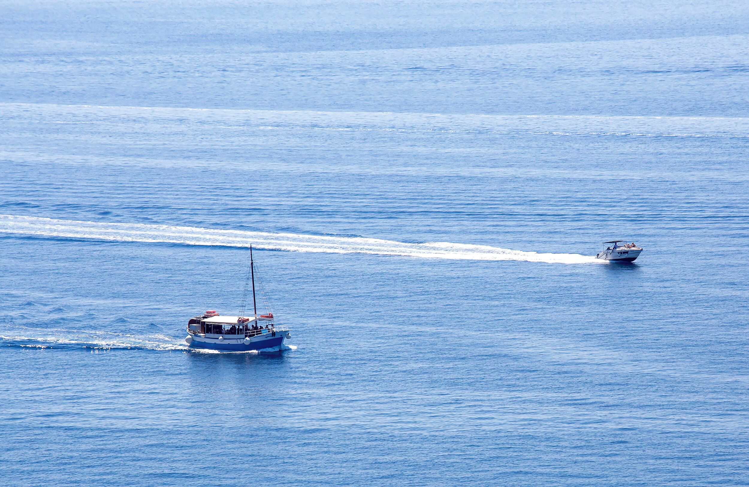 Un barco en un mar tranquilo dejando una estela detrás.