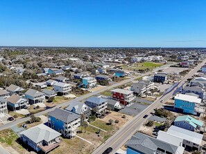 An aerial view of a residential area with houses, roads, and a clear sky. - Coral House: Spacious oceanview retreat in Oak Island, NC, perfect for families. (Oak Island)