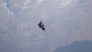 A paraglider flying over a mountainous landscape. - Hotel Nirbana Heights (Dharamshala)