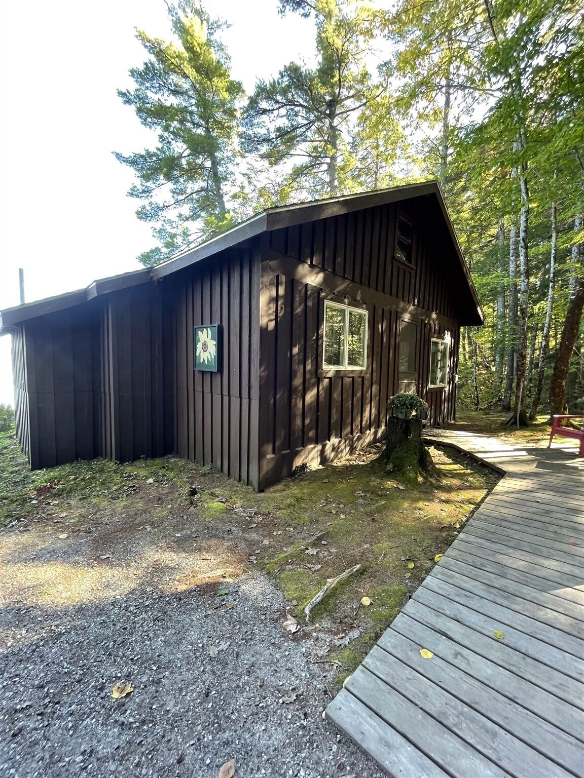 A rustic cabin with a wooden exterior, a porch, and a small deck.