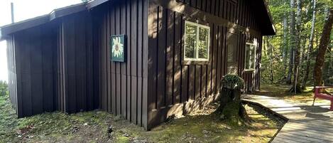 A rustic cabin with a wooden exterior, a porch, and a small deck.