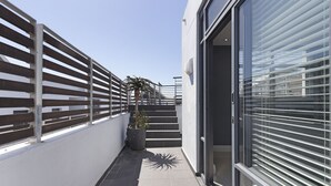 Un bâtiment moderne, doté d’une clôture en métal, d’un pot de fleurs et d’un escalier menant à l’entrée.
