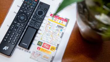 Two remote controls and a welcome brochure on a table.