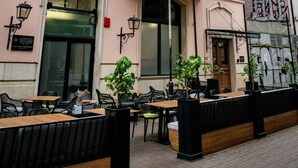 Un edificio rosa con terraza, amplias ventanas y un balcón.