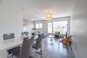 A modern apartment with a dining area, kitchen, and a balcony with a view. - SmartStay Le Thiou - Annecy centre (Annecy)