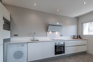 A modern kitchen with built-in appliances, a large window, and recessed ceiling lights. - SmartStay Le Thiou - Annecy centre (Annecy)
