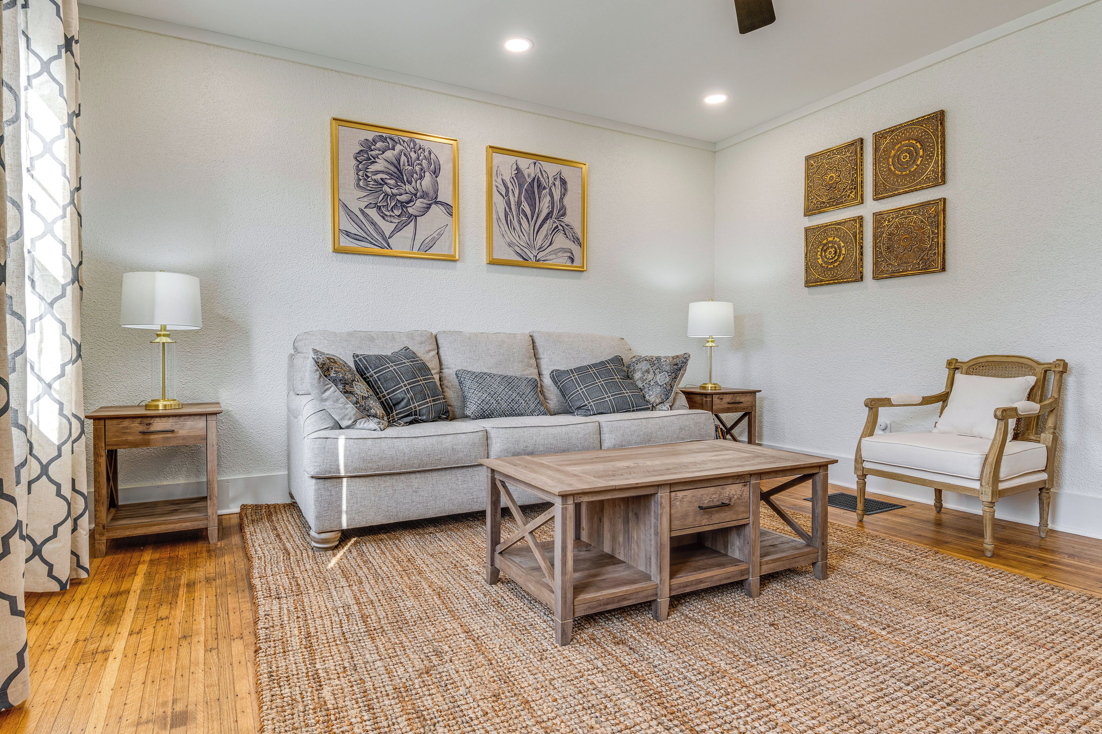 A living room with a sofa, a wooden coffee table, a chair, and a patterned rug.