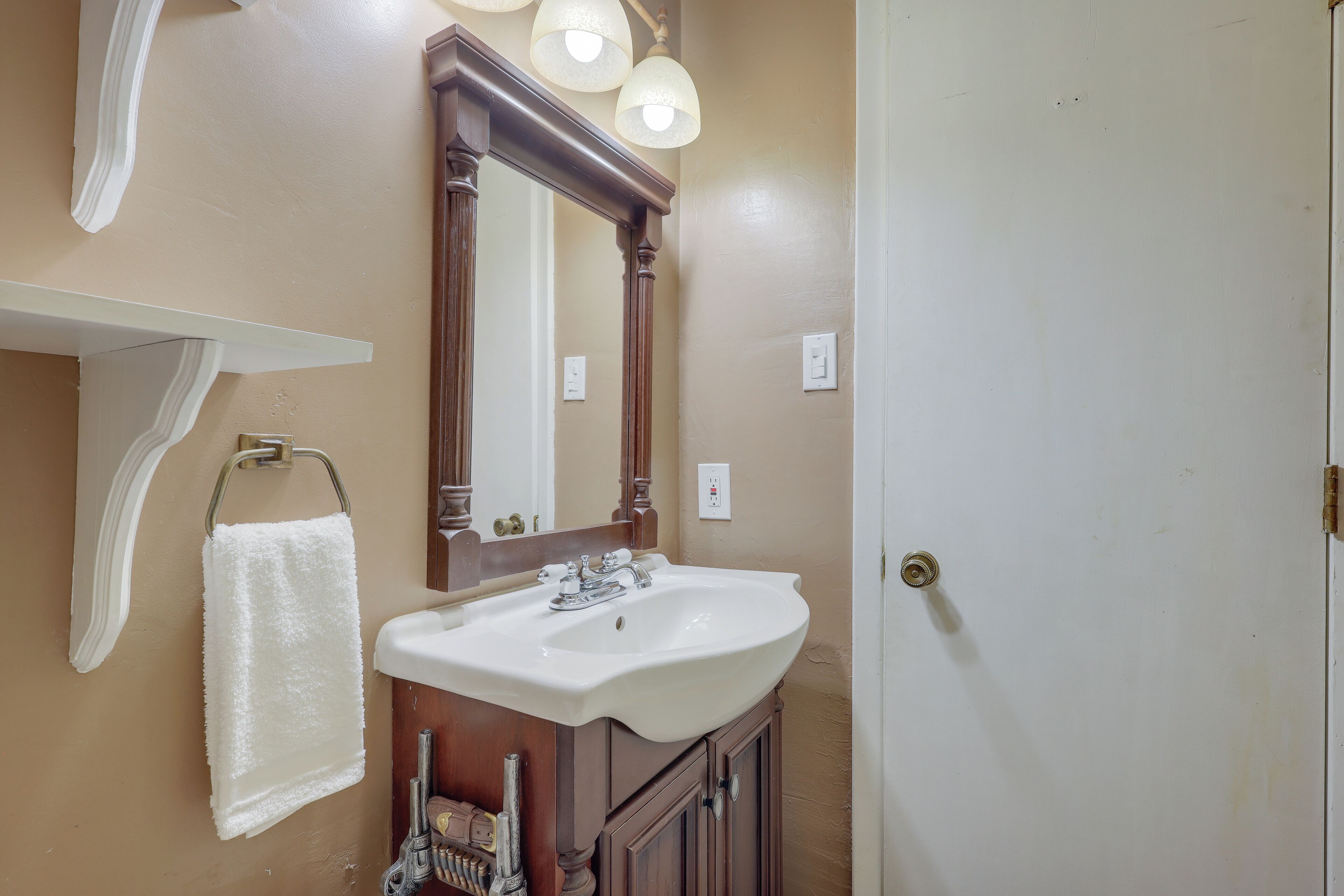 Une salle de bain avec un lavabo blanc, un miroir et une serviette suspendue à un porte-serviettes.