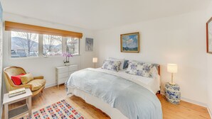 A bedroom with a bed, a chair, a nightstand, a lamp, a window, and a painting on the wall. - Ketchum Vacation Rental - Hike, Ski & Explore! (Ketchum)