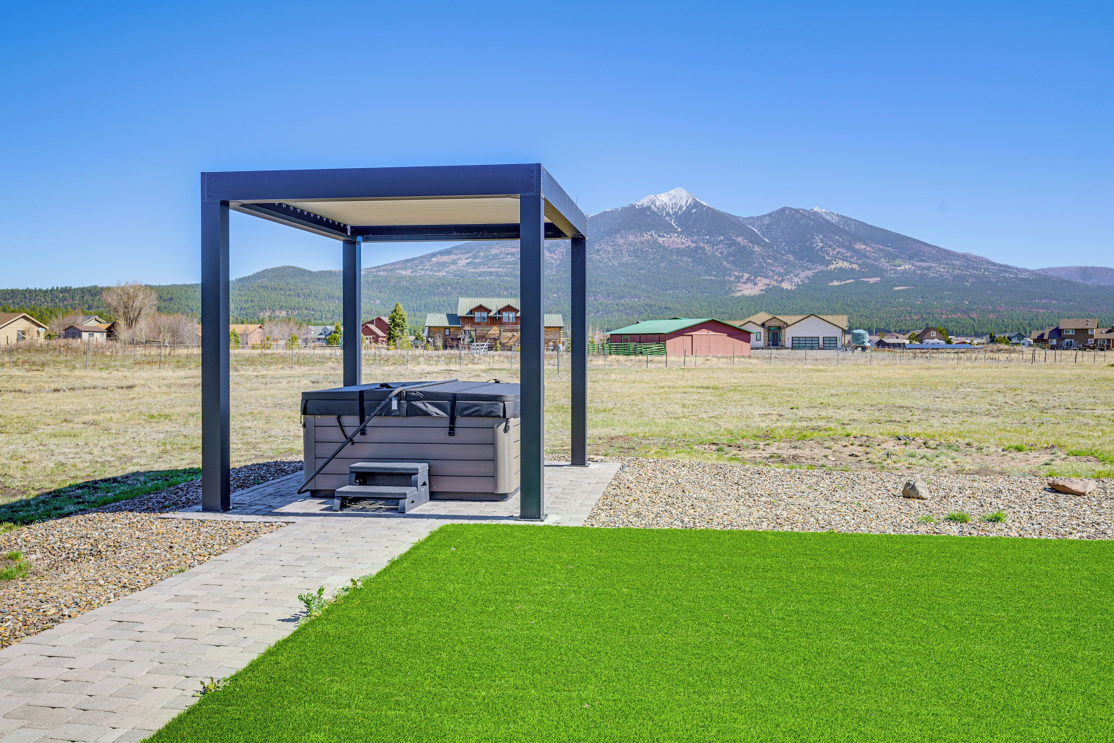 Un espace extérieur aménagé, abrité et doté d’un barbecue, d’un chemin pavé et d’une pelouse.