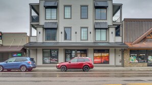 A two-story building with a modern design, featuring large windows and a flat roof. - Downtown Columbia Falls Condo: 16 Mi to Ski Resort (Columbia Falls)
