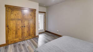 A bedroom with a bed, wooden wardrobe, and a ceiling fan. - Downtown Columbia Falls Condo: 16 Mi to Ski Resort (Columbia Falls)