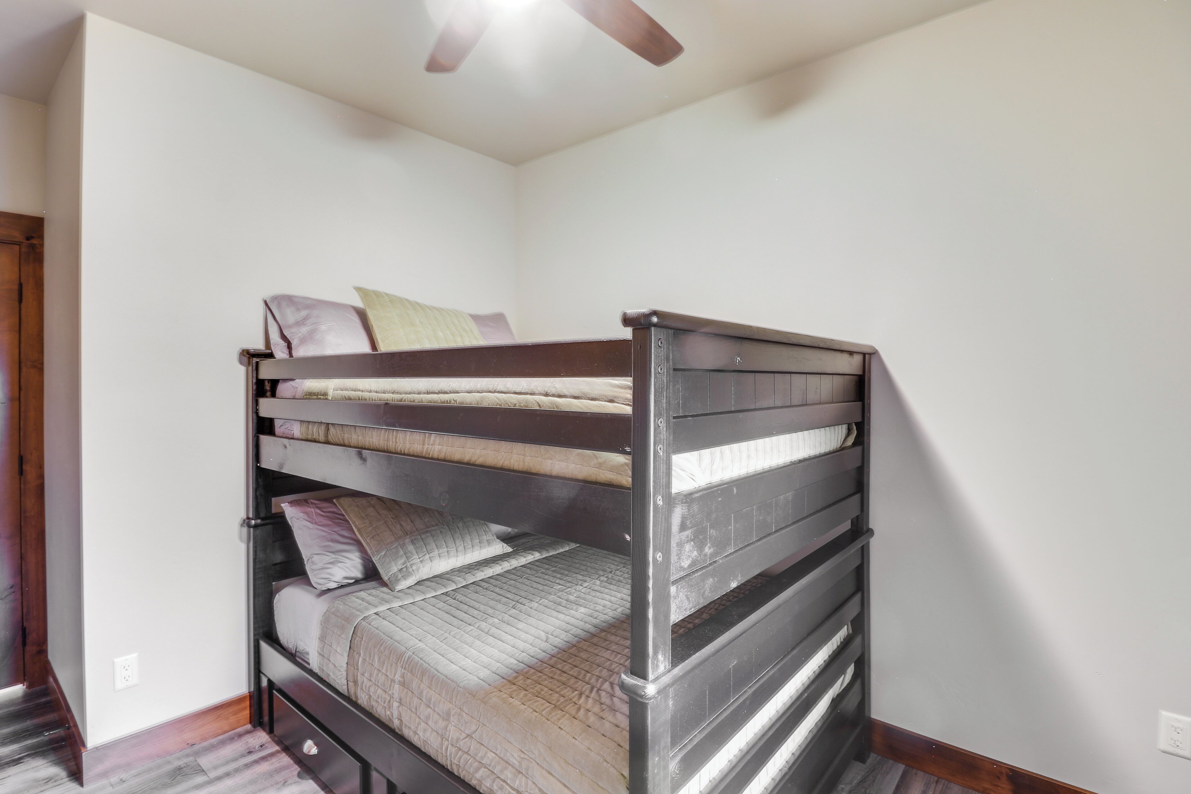 A bunk bed in a room with white walls and a wooden floor.