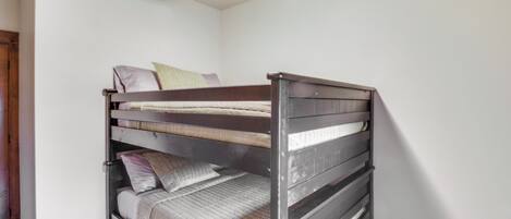 A bunk bed in a room with white walls and a wooden floor.