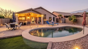 A backyard with a swimming pool, patio furniture, and a covered outdoor seating area. - Gold Canyon Superstition Foothills Retreat w/ Pool (Gold Canyon)