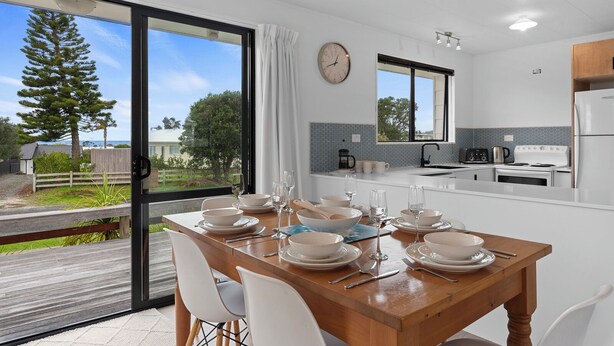 Una cocina moderna con comedor, ventanas amplias y vistas al exterior.