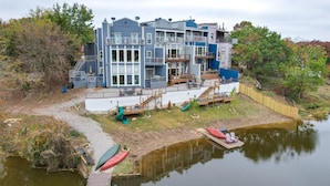 A multi-story waterfront property with balconies, a dock, and a small boat. - Lakefront Townhome in Pottsboro: Pets Welcome! (Pottsboro)