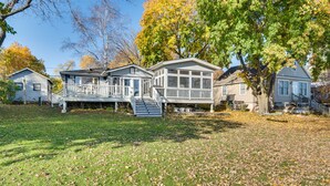 A row of single-story houses with front porches and a grassy yard. - Lakefront Edgerton Cottage w/ Deck & Grill! (Edgerton)