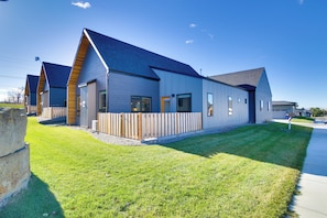 A modern building with a sloped roof, large windows, and a fenced outdoor area. - Pet-friendly Bozeman Home ~ 7 Mi to Downtown! (Bozeman)