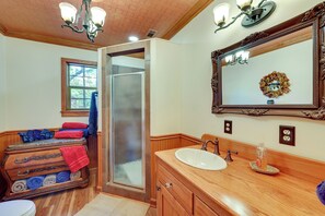 Enjoy a classic bathroom with a vanity, mirror, shower, and towel rack.