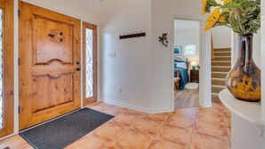 A wooden door with a glass panel, a coat rack, and a vase with sunflowers. - Jonestown Retreat w/ Deck: 6 Mi to Lake Travis! (Leander)