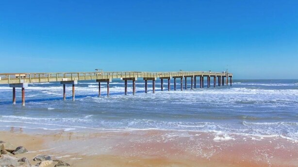 A pier extending into the ocean with a clear sky above. - Historic district- yard, putting green, firepit (Saint Augustine)