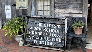 A rustic wooden building with a sign stating it's the oldest wooden schoolhouse in the USA, located in St. Augustine, Florida. - Historic district- yard, putting green, firepit (Saint Augustine)