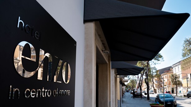 A hotel sign with the name "Enzo" and the phrase "in centro del mare" indicating its location. - Hotel Enzo (Porto Recanati)