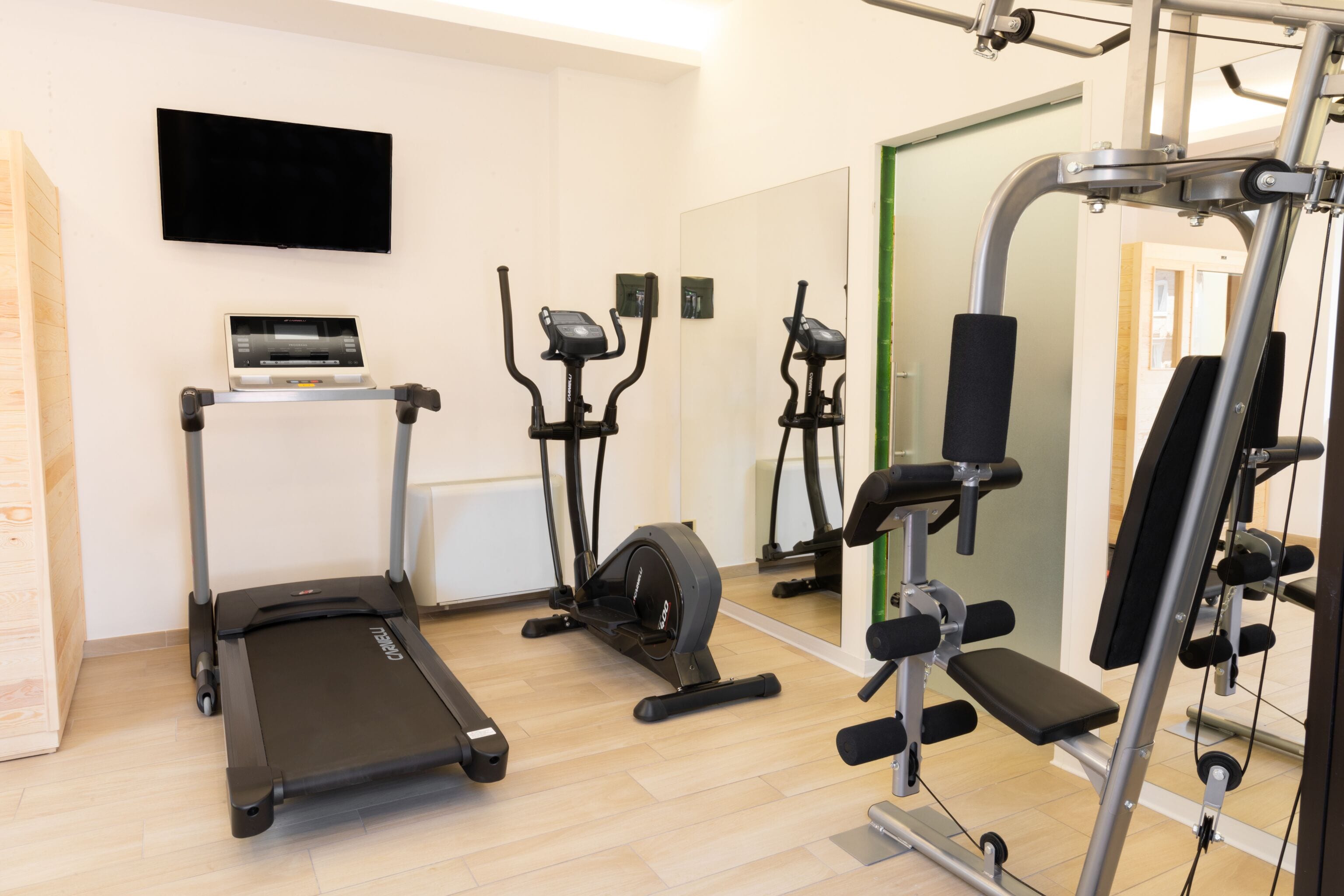 Ein Fitnessstudio mit Laufbändern, Crosstrainern und Gewichtmaschinen.