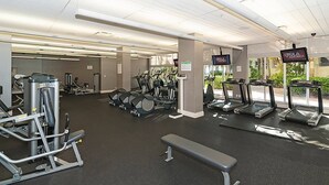 A gym with treadmills, weight machines, and a bench. - Beachfront Apt | Tides Hollywood 5th Floor + Pool (Hollywood)