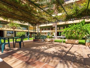 A courtyard with a covered seating area, outdoor furniture, and potted plants. - El Remo - Terrace, Swimming Pool, Parking, Sea Views. 2 bedrooms (Torremolinos)