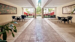 A spacious indoor area with tiled flooring, black chairs, and tables arranged for dining or meetings. - Sabbia 3401a- 2bedrooms All-in Suite (Playa del Carmen)