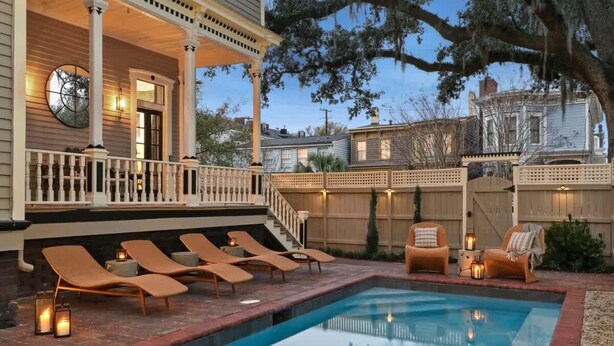 Ein Poolbereich mit Liegestühlen und einer überdachten Terrasse.
