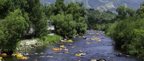 Un río con varias personas en balsas inflables.