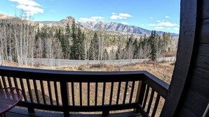 A wooden deck with a view of a mountain range and a road. - Amazing Mountain Views ! Two Miles From Purgatory Ski Resort (Durango)