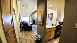 A spacious living area with a stone fireplace, wooden flooring, and a dining table. - Amazing Mountain Views ! Two Miles From Purgatory Ski Resort (Durango)